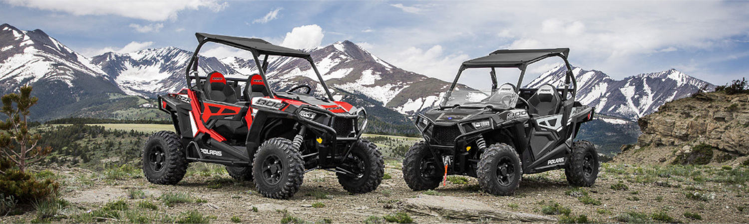 Two 2022 Polaris® next to each other with a mountain range in the background.